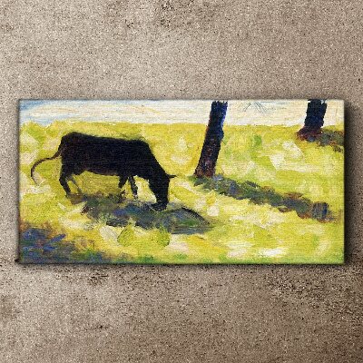 A cow grazing in a green landscape Canvas print