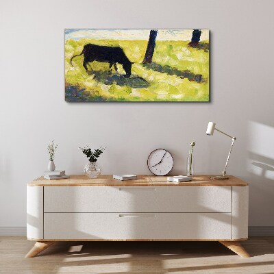 A cow grazing in a green landscape Canvas print