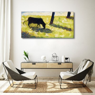 A cow grazing in a green landscape Canvas print