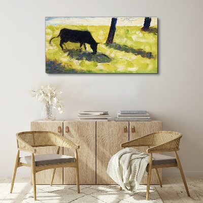 A cow grazing in a green landscape Canvas print