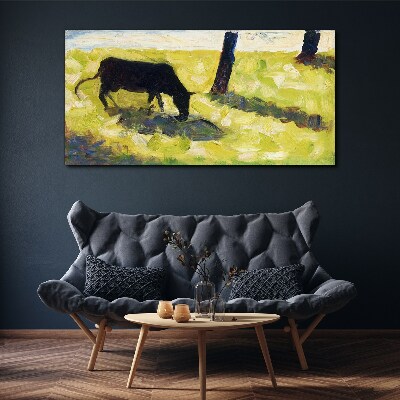 A cow grazing in a green landscape Canvas print