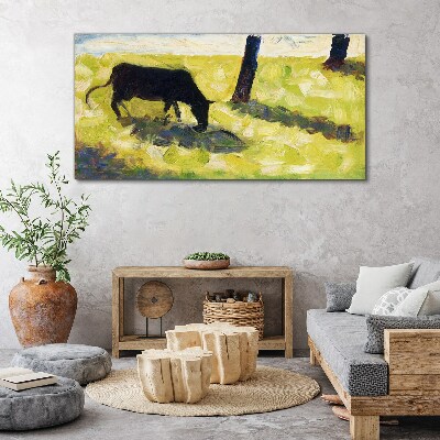 A cow grazing in a green landscape Canvas print