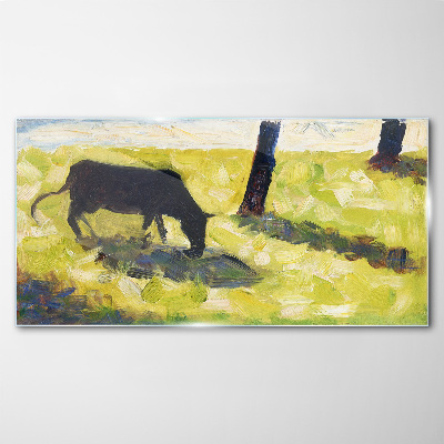 A cow grazing in a green landscape Glass Wall Art