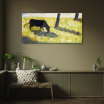 A cow grazing in a green landscape Glass Wall Art
