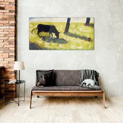 A cow grazing in a green landscape Glass Wall Art