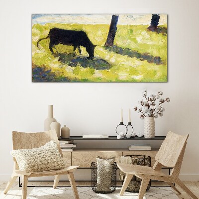 A cow grazing in a green landscape Glass Wall Art