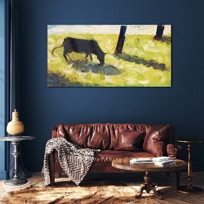 A cow grazing in a green landscape Glass Wall Art