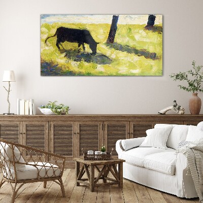 A cow grazing in a green landscape Glass Wall Art