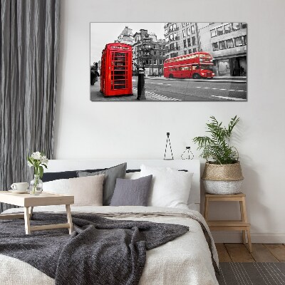 Red telephone in a grey city Glass Wall Art