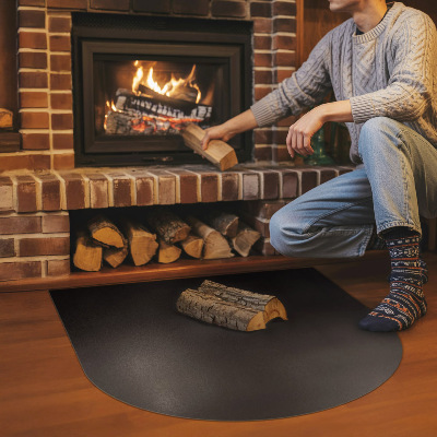 Fireplace pad in a semi-oval shape made from black steel sheet