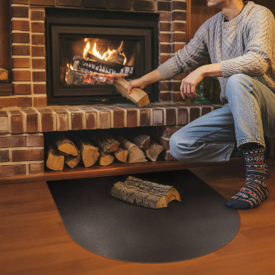 Fireplace pad in a semi-oval shape made from black steel sheet
