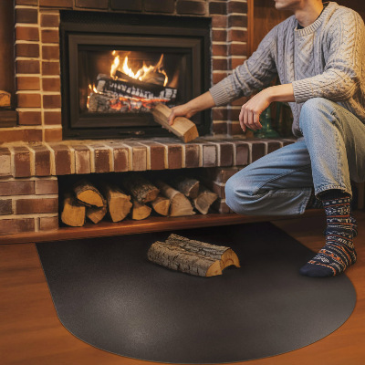 Fireplace pad in a semi-oval shape made from black steel sheet