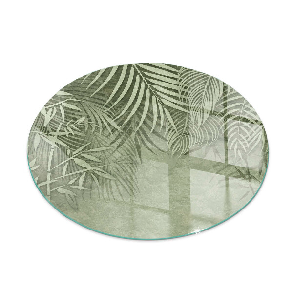 Glass hearth pad round Tropical leaves in the background