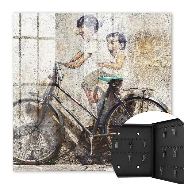Key cabinet Children and a bicycle against an old wall